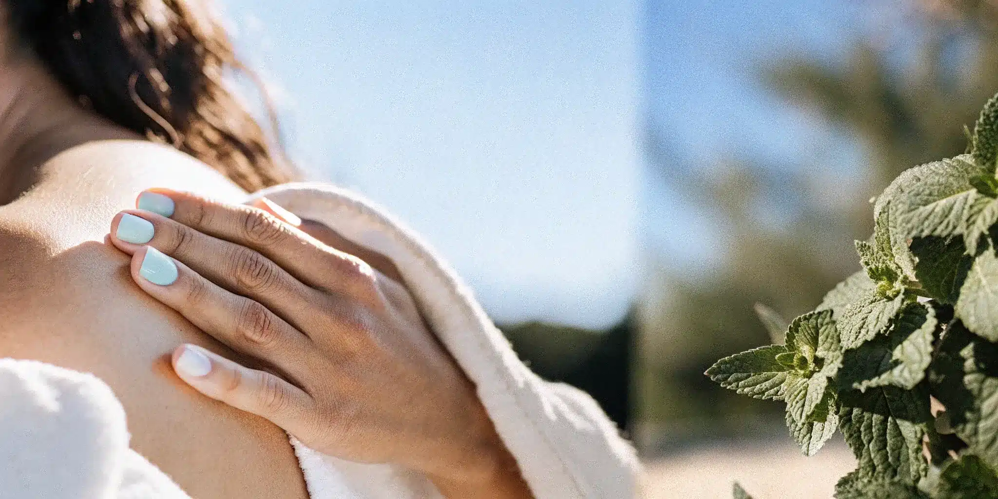 the-ultimate-guide-to-menthol-camphor-rub-328601 Hand applying menthol camphor rub to a sore shoulder with fresh mint leaves.