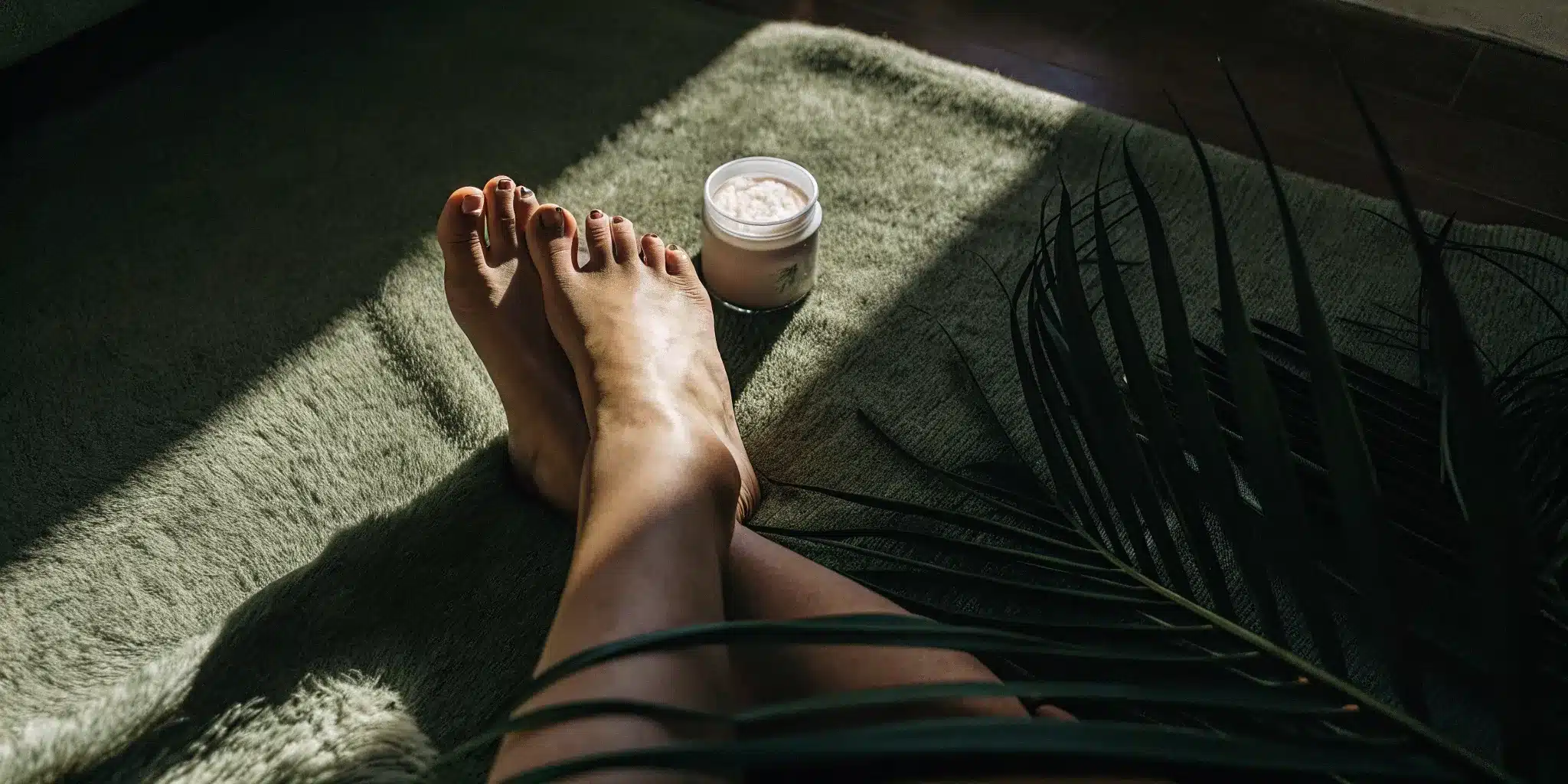 top-5-best-foot-creams-for-standing-all-day-492600 Relaxed feet resting next to a jar of the best foot cream for standing all day.